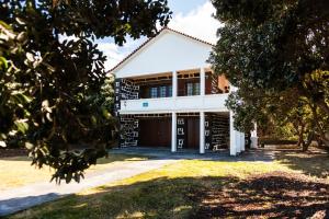 a house with a garage and trees in front of it at Adega do Pereirinha in São Roque do Pico