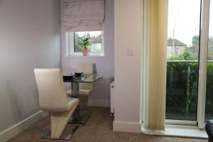 Zimmer mit einem Tisch, einem Stuhl und einem Fenster in der Unterkunft Letting Serviced Apartments - Central St Albans in St Albans