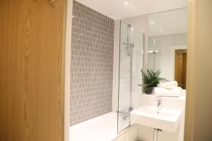 ein Badezimmer mit Dusche, Waschbecken und Spiegel in der Unterkunft Letting Serviced Apartments - Central St Albans in St Albans + 2 Fotos