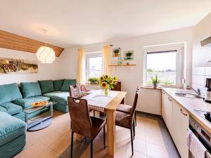 a kitchen and living room with a table and a couch at Landhotel & Reiterhof Schumann in Triptis