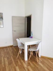 a white table and two chairs in a room at Ferienwohnung Susanna in Friedrichshafen