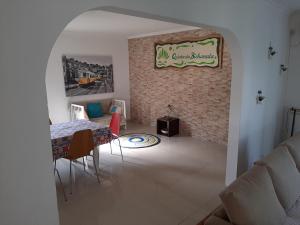 a living room with a table and a brick wall at Quinta da Bicharada in Pinhal Novo