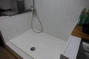 a shower with a hose hanging from a wall at 1-BedCottage ModrnKitchen CarCharging Tv Wifi in Coleford