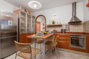 cocina con mesa, sillas y nevera en Villa Rožica, en Rijeka