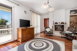 ein Wohnzimmer mit einem TV und einem Kamin in der Unterkunft Villa Rožica in Rijeka