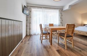 jadalnia ze stołem, krzesłami i łóżkiem w obiekcie Appartements Haus Alexander w Saalbach Hinterglemm