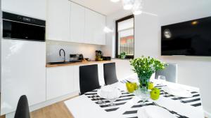 a kitchen with a table with a vase of fruit on it at HELLO Apartament z ogrodem - Alpina in Karpacz