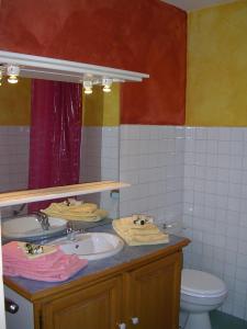 ブリッド・レ・バンにあるAppartement avec Terrasse centre Bridesのバスルーム(洗面台2台、トイレ、鏡付)