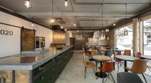 a kitchen with green cabinets and tables and chairs at GH1 Aparthotel am Glockenplatz in Ehingen