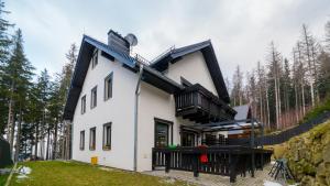 a white house with a black roof at HELLO Apartament z ogrodem - Alpina in Karpacz