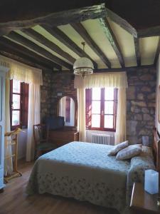 a bedroom with a bed and some windows at Posada Campo in Suances