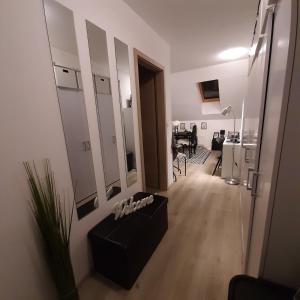 a living room with a black couch and a mirror at Apartment Mansarda in Maribor