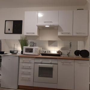 a kitchen with white cabinets and a microwave at Apartment Mansarda in Maribor