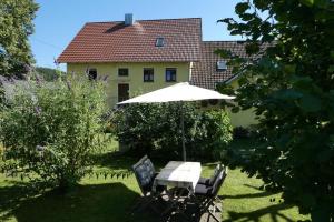 a table and chairs under an umbrella in a yard at Ferienwohnung Schindler in Nittenau