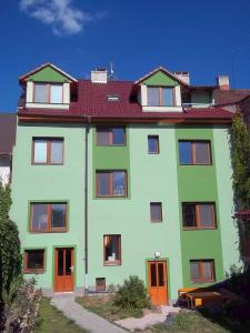 ein großes grünes Gebäude mit rotem Dach in der Unterkunft Penzion Apartmány Zlín in Zlín