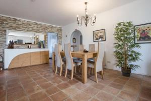 a dining room and kitchen with a table and chairs at Vivenda Idalina in Sagres