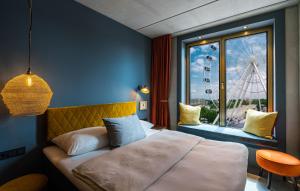een slaapkamer met een bed en een raam met een reuzenrad bij gambino hotel WERKSVIERTEL in München
