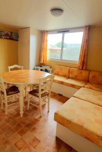uma sala de estar com uma mesa e um sofá em RESIDENCE TORRE DEL FAR em Tautavel