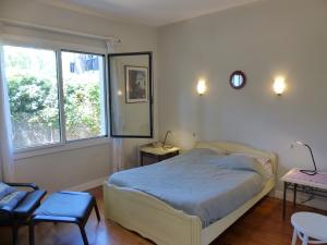 een slaapkamer met een bed en een groot raam bij Villa Haristeguia Pour 8 Personnes Entre Lac Et Ocean in Hossegor