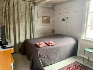 um quarto com uma cama com duas toalhas cor-de-rosa em Pensionat Gyllenhjelmsgatan em Strängnäs