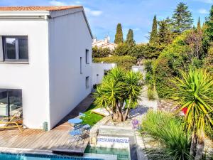 濱海薩納里的住宿－La Villa Blanche，享有带游泳池和植物的房子的景色