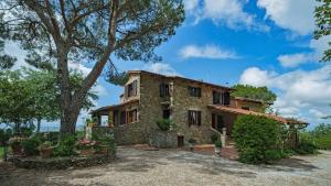 - une vue sur l'extérieur d'une maison en pierre avec des arbres dans l'établissement Solaria di Santa Maddalena 14, à Castelnuovo Berardenga