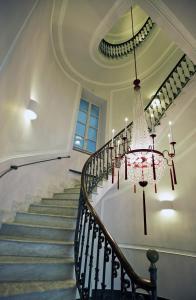 a chandelier hangs from a staircase in a house at Albergo Palazzo Decumani in Naples