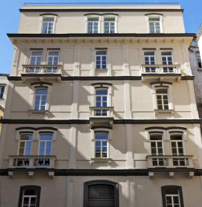 um edifício branco alto com muitas janelas em Albergo Palazzo Decumani em Nápoles