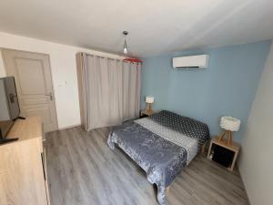 Dormitorio pequeño con cama y TV en Gîte du ruisseau, en Nissan-lez-Enserune