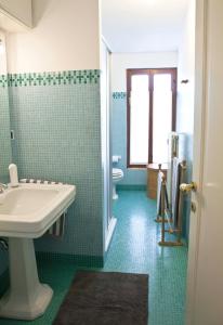 a bathroom with a sink and a toilet and a window at B&B ViaCavourSei in Portogruaro