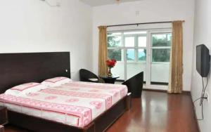 a bedroom with a bed and a television in it at Apple Breeze Resort in Kotagiri