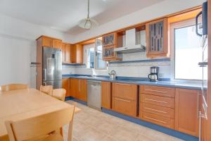 a kitchen with wooden cabinets and a wooden table with a tableablish at Casa Oasis in Tías