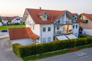 uma casa branca com um telhado vermelho em Ferienwohnung Altötting em Unterneukirchen