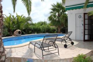 zwei Stühle neben einem Swimmingpool in der Unterkunft Riumar "Noella", 200m to beach, private pool, On-Site-Service, dog beach in Riumar