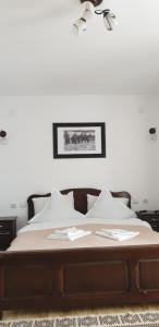 a bedroom with a bed with white pillows at Pensiunea Catalina in Moldova Suliţa
