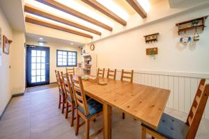 a kitchen and dining room with a wooden table and chairs at Summer Tree Homestay in Tainan