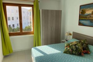 a bedroom with a bed with green curtains and a window at Apartamento Portobello in Port de Pollensa +15 photos