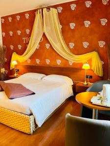 Villa Riviera Hotel Udine في Pradamano: غرفة الفندق بسرير مع مظلة