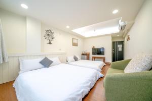 um quarto com 2 camas e um sofá em Summer Tree Homestay em Tainan