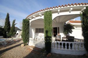 una casa con un arco con mesa y sillas en Riumar "Lorenzo", 400m to beach, private pool, On-Site-Service, dog beach, en Riumar