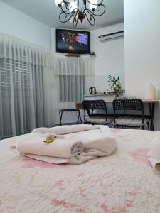 1 dormitorio con 1 cama con toallas en Carmela Studio, en Arad