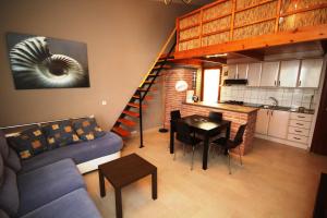 ein Wohnzimmer mit einem Sofa, einem Tisch und einer Treppe in der Unterkunft Riumar "Josef", 490m to beach, private pool, On-Site-Service, dog beach in Riumar