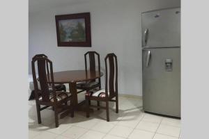 a kitchen with a table and three chairs and a refrigerator at Apartamento en el Laguito Cartagena in Cartagena de Indias