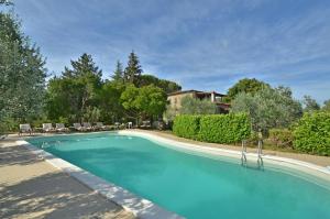Una piscina con sillas y una casa al fondo. en Poggio Landi, en Bucine