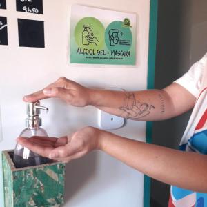 Uma mulher com uma tatuagem no braço a entrar num dispensador. em Meu Hostel em Maceió