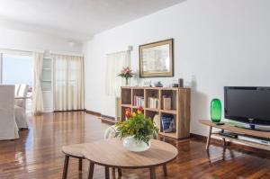 a living room with a table and a tv at Villa Erofili in Fira