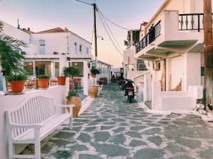 a street with white buildings and a white bench at Villa Stamatis in Áyioi Apóstoloi