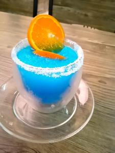 uma bebida azul numa taça de vidro com uma fatia de laranja em Mateoasis em Ko Kood