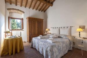 a bedroom with a bed and a table and a window at Tignano in Tavarnelle in Val di Pesa +40 photos