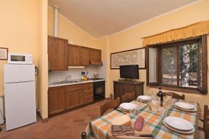 eine Küche mit einem Tisch und einem weißen Kühlschrank in der Unterkunft Timo in Gaiole in Chianti